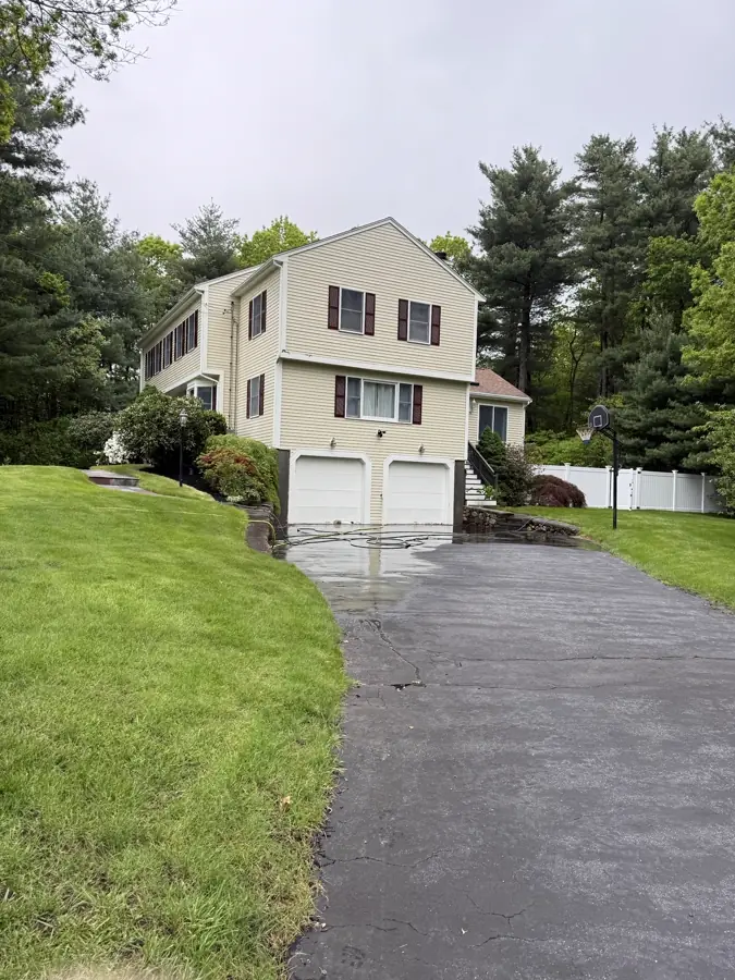 Yellow colonial and driveway after a Callahan house wash