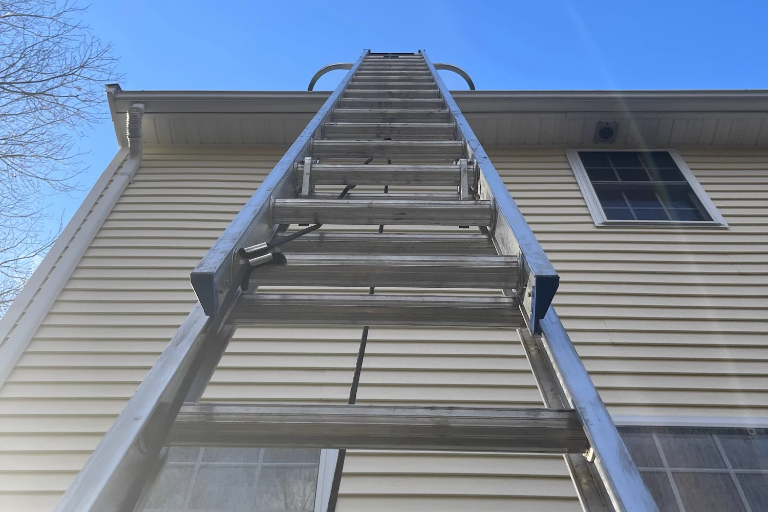 Callahan Exterior Cleaning ladder and chimney work on a roof in Massachusetts